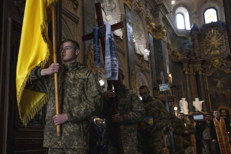 Soldiers carry the coffins of 39-year-old junior sergeant, Pohylenko Dmytro, and 40-year-old Senior lieutenant, Oliynyk Dmytro, during their funeral ceremony, after being killed in action, in the Holy Apostles Peter and Paul Church, in Lviv, western Ukraine, Saturday, April 2, 2022. (AP Photo/Nariman El-Mofty)