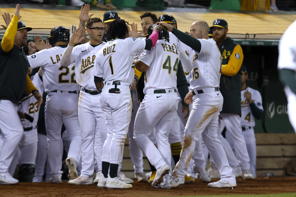 Oakland Athletics' Carlos Perez (44) is congratulated by teammates after driving in a run with a groundout during the eighth inning of a baseball game against the Tampa Bay Rays in Oakland, Calif., Tuesday, June 13, 2023. (AP Photo/Jed Jacobsohn)