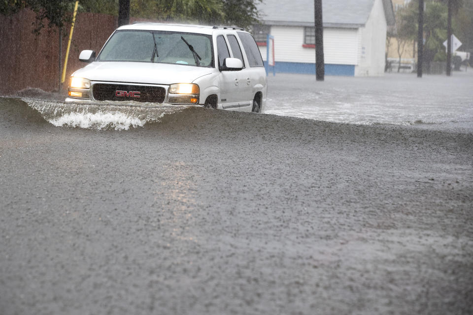 A vehicle drives through floodwaters from Tropical Storm Beta Tuesday, Sept. 22, 2020, in Galveston, Texas. Beta has weakened to a tropical depression as it parked itself over the Texas coast, raising concerns of extensive flooding in Houston and areas further inland. (Brett Coomer/Houston Chronicle via AP)