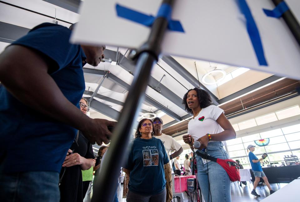 City of Bloomington's Safe and Civil City Director Shatoyia Moss explains the marker to attendees of the Underground Railroad marker reveal during the annual Juneteenth Celebration at Switchyard Park on Saturday.