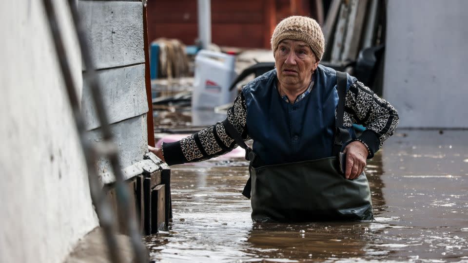 A woman walks near her flooded house in Orenburg on Wednesday. - AP