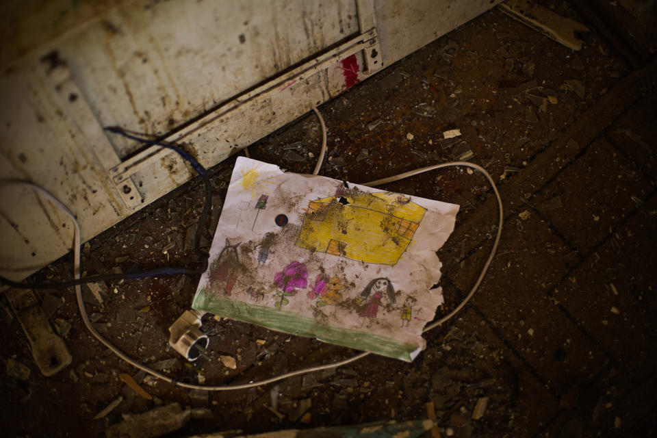 A child's drawing lays on the floor of Iryna Martsyniuk's home, heavily damaged after a Russian bombing in Velyka Kostromka village, Ukraine, Thursday, May 19, 2022. Martsyniuk and her three young children were at home when the attack occurred in the village, a few kilometres from the front lines, but they all survived unharmed. (AP Photo/Francisco Seco)