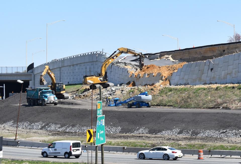 Demolition work continues Tuesday on a failed retaining wall off Interstate 295 in Bellmawr.