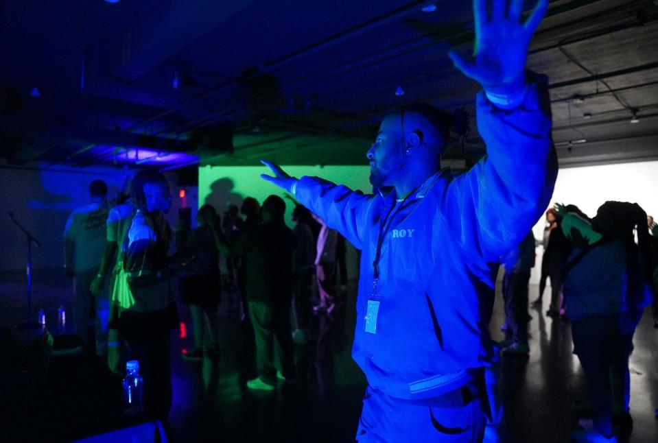 One of The Cove's seven co-founders, Aaron Dews, raises his arms in worship after a night of dancing.