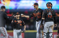 Baltimore Orioles relief pitcher Branden Kline, second from right, is pulled from a baseball game against the Seattle Mariners in the fifth inning by manager Brandon Hyde, left, as third baseman Rio Ruiz and catcher Chance Sisco stand at the mound Friday, June 21, 2019, in Seattle. (AP Photo/Stephen Brashear)