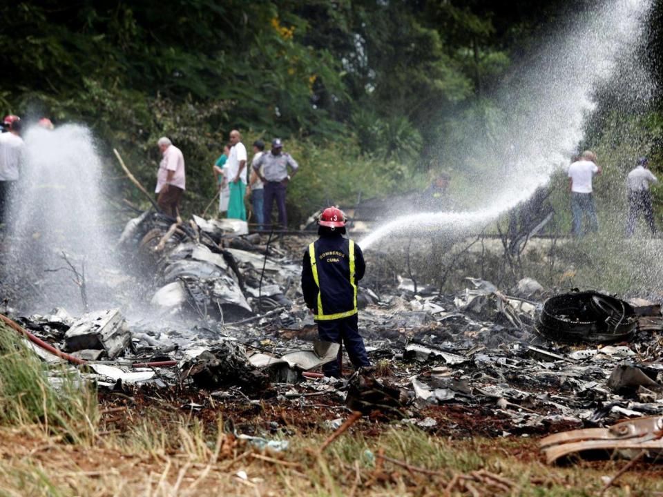 A firefighter works in the wreckage of a Boeing 737 plane that crashed in the agricultural area of Boyeros, around 12 miles south of Havana (Reuters)