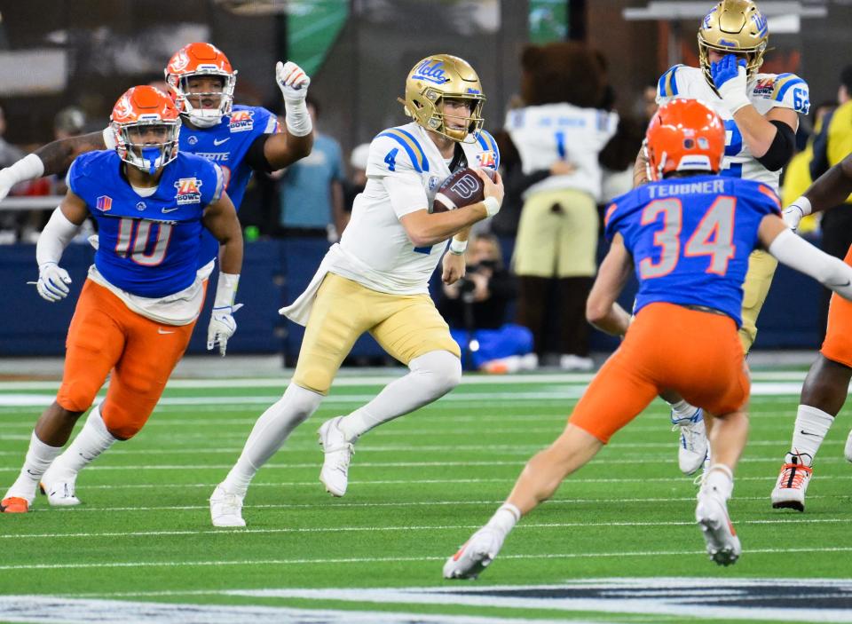 UCLA Bruins quarterback Ethan Garbers (4) scrambles out of the pocket between Boise State Broncos linebacker Andrew Simpson (10) and safety Alexander Teubner (34) during the third quarter at the 2023 Starco Brands LA Bowl at SoFi Stadium.