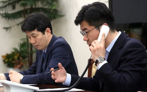 An official talks on a phone for testing a hotline between the two Koreas at the Presidential Blue House in Seoul - Credit: Reuters