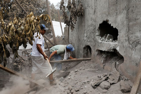 People inspect an affected area after the eruption of the Fuego volcano in Escuintla, Guatemala, June 8, 2018. REUTERS/Carlos Jasso