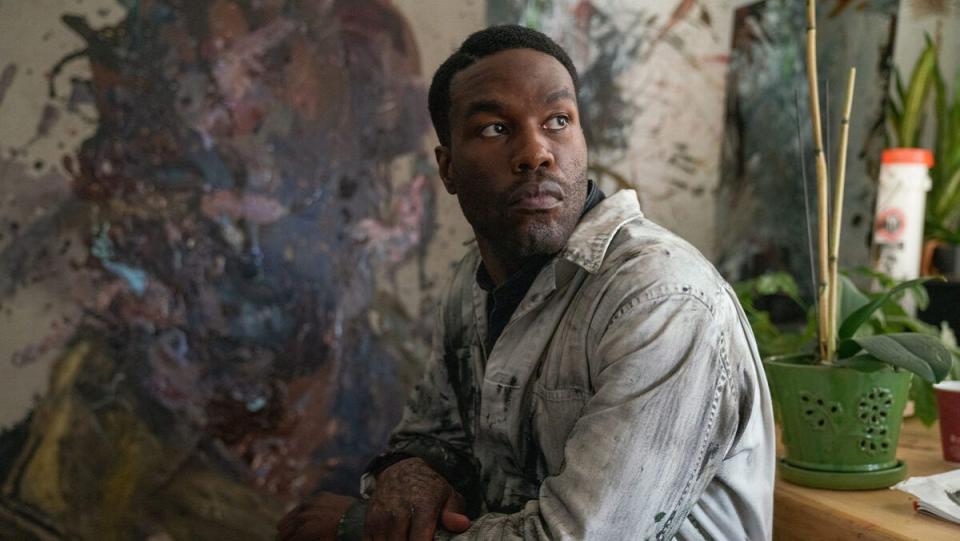 Anthony (Yahya Abdul-Mateen II) sits among his art in Candyman.