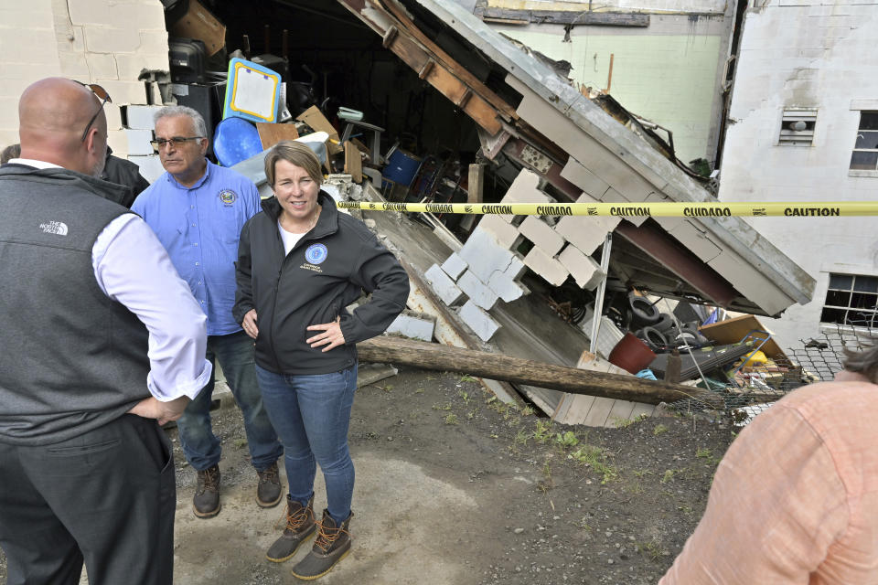 Gov. Maura Healey, third left, visits the site of a building which collapsed after a storm Tuesday, Sept. 12, 2023, in Leominster, Mass. More than 9 inches of rain fell in the town overnight. (AP Photo/Josh Reynolds)