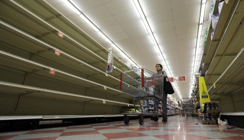 <p>Shoppers pass empty shelves along the bottled water aisle in a Houston grocery store as Hurricane Harvey intensifies in the Gulf of Mexico, Thursday, Aug. 24, 2017. (Photo: David J. Phillip/AP) </p>