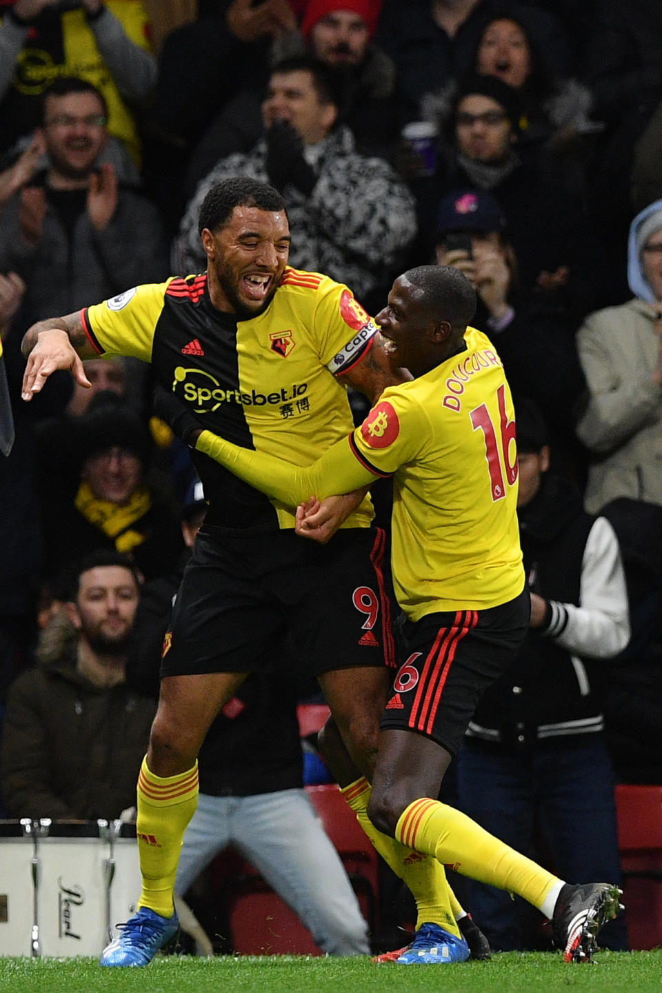 Watford's English striker Troy Deeney (L) celebrates with Watford's French midfielder Abdoulaye Doucoure after scoring his team's third goal during the English Premier League football match between Watford and Liverpool at Vicarage Road Stadium in Watford, north of London on February 29, 2020. (Photo by Justin TALLIS / AFP) / RESTRICTED TO EDITORIAL USE. No use with unauthorized audio, video, data, fixture lists, club/league logos or 'live' services. Online in-match use limited to 120 images. An additional 40 images may be used in extra time. No video emulation. Social media in-match use limited to 120 images. An additional 40 images may be used in extra time. No use in betting publications, games or single club/league/player publications. /  (Photo by JUSTIN TALLIS/AFP via Getty Images)