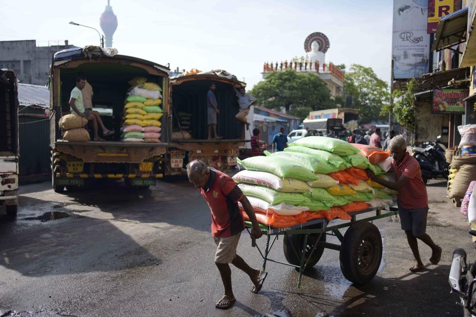 Laborers transport a cart load of rice sacks at a market place in Colombo, Sri Lanka, Monday, Nov. 14, 2022. (AP Photo/Eranga Jayawardena)