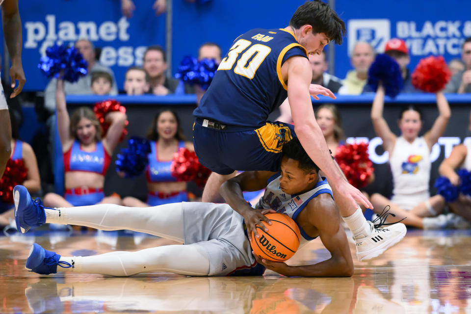 Kansas guard Elmarko Jackson comes up with control of the ball below Kansas City guard Cameron Faas (30) during the first half of an NCAA college basketball game in Lawrence, Kan., Tuesday, Dec. 5, 2023. (AP Photo/Reed Hoffmann)