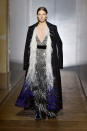 <p>Ein Model trägt bei der Givenchy Frühjahr/Sommer 18 Haute Couture Modenschau ein silbernes Fransenkleid mit Pailletten und Perlen unter einem schwarzen federbesetzten Mantel. (Bild: Getty Images) </p>