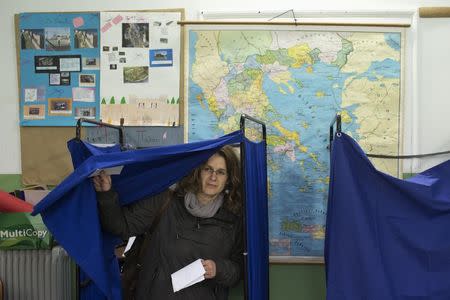 A woman exits a voting booth to cast her ballot at a polling station in an elementary school during Greece's parliamentary elections in Athens January 25, 2015. REUTERS/Marko Djurica