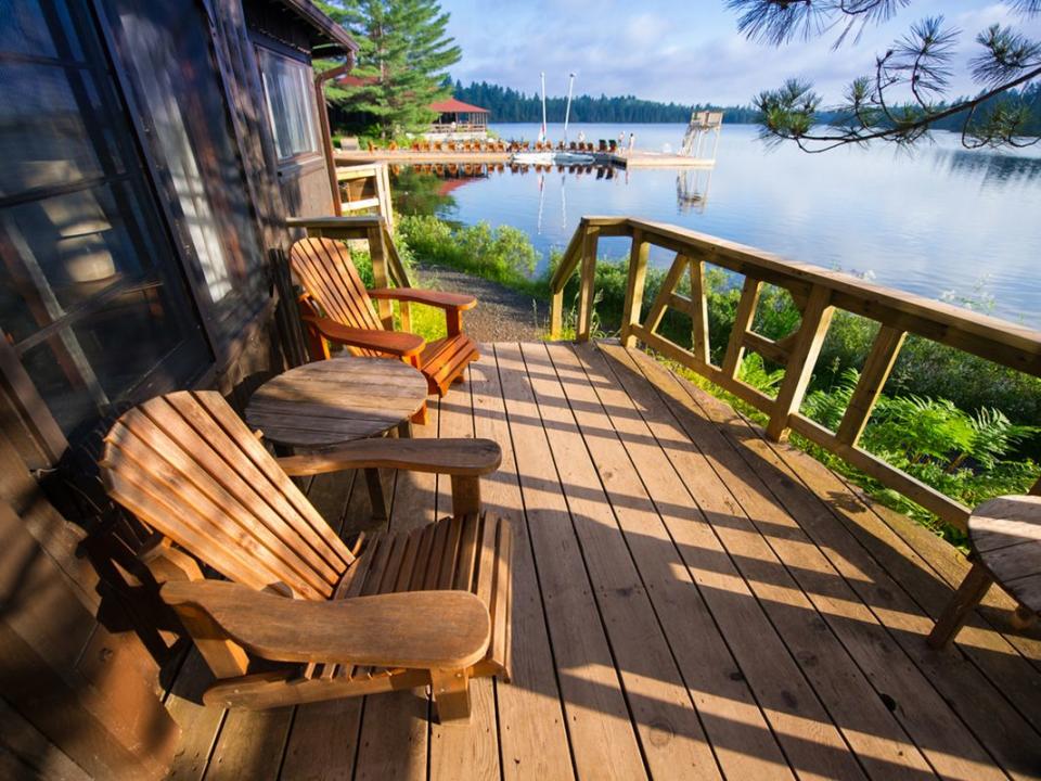 Muskoka chairs sitting on a wooden porch