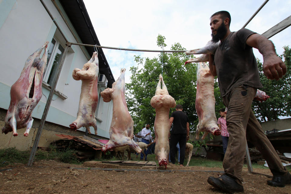 A man carry a carcass of a sacrificed sheep during the Muslim holiday of Eid al-Adha in the town of Saky, Crimea July 31, 2020. REUTERS/Alexey Pavlishak