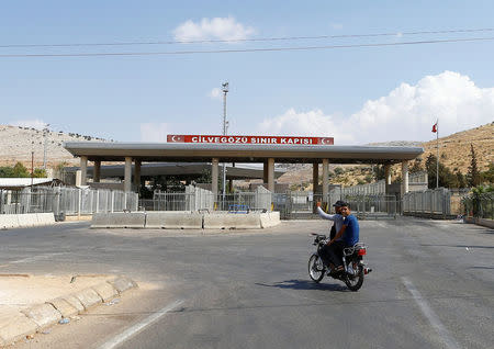 A Syrian man rides a motorcycle at the Turkish Cilvegozu border gate, located opposite the Syrian commercial crossing point Bab al-Hawa, in Reyhanli, Hatay province, Turkey, September 14, 2016. REUTERS/Osman Orsal