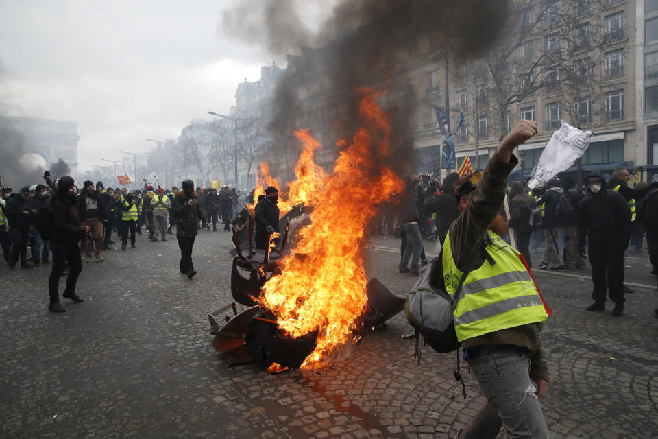 A barricade burns on the Champs Elysees avenue Saturday, March 16, 2019 in Paris. French yellow vest protesters clashed Saturday with riot police near the Arc de Triomphe as they kicked off their 18th straight weekend of demonstrations against President Emmanuel Macron. (AP Photo/Christophe Ena)