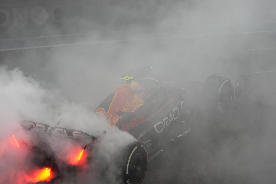 El mexicano Sergio Pérez, de Red Bull, quema neumáticos tras conseguir el tercer puesto del campeonato mundial de pilotos en el Gran Premio de Abu Dabi, el domingo 20 de noviembre de 2022 (AP Foto/Hussein Malla)