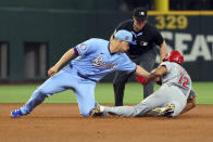 Texas Rangers shortstop Corey Seager, left, tags Cincinnati Reds' Bubba Thompson (12) in the ninth inning of a baseball game Sunday, April 28, 2024, in Arlington, Texas. Thompson was initially called out but was ruled safe after a review. (AP Photo/Richard W. Rodriguez)