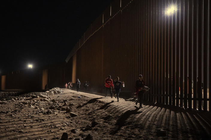 Migrants walk along the US-Mexico border fence on June 6, 2023 in Yuma, Arizona.  Fewer migrants arrived at the border after the 42 title expired. / Credit: Qian Weizhong/VCG via Getty Images