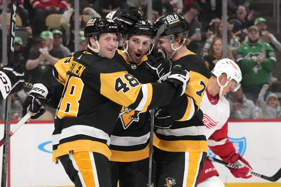 Pittsburgh Penguins' Michael Bunting (8) celebrates his goal with Valtteri Puustinen (48) and John Ludvig (7) during the second period of an NHL hockey game against the Detroit Red Wings in Pittsburgh, Sunday, March 17, 2024. (AP Photo/Gene J. Puskar)
