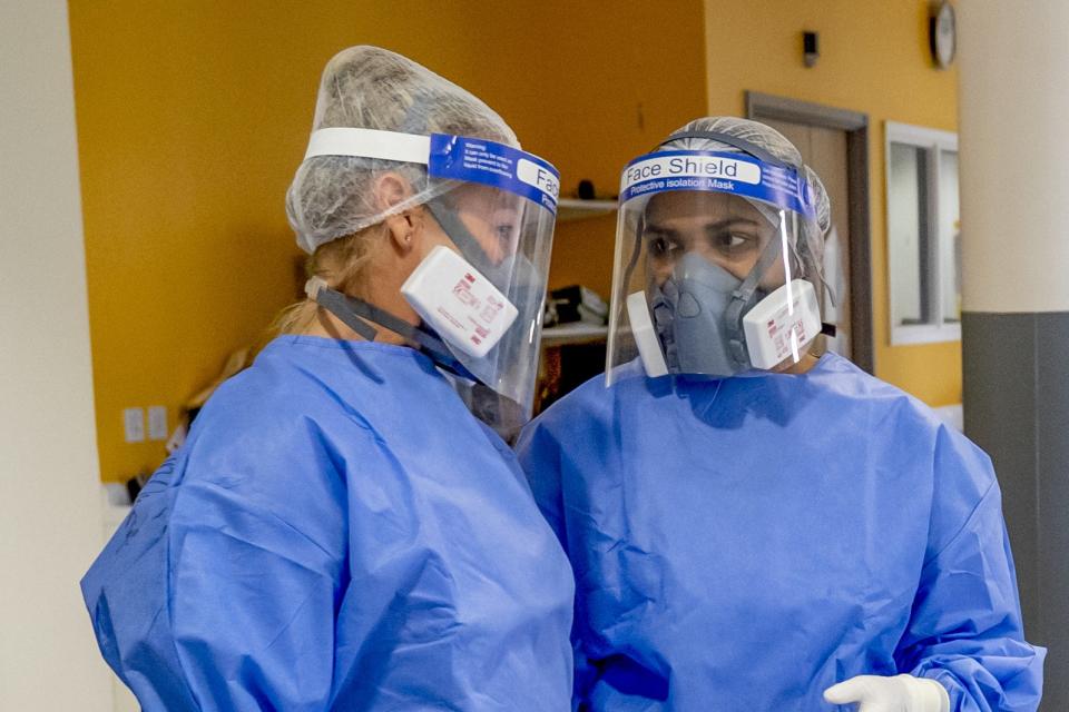 <p>Health workers wearing full personal protective equipment (PPE) on the intensive care unit (ICU) at Whiston Hospital </p> (PA)