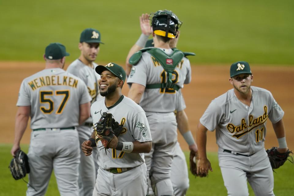 Oakland Athletics' Elvis Andrus, left front, Jacob Wilson (11), J.B. Wendelken (57) and others celebrate their win over the Texas Rangers in a baseball game in Arlington, Texas, Saturday, July 10, 2021. (AP Photo/Tony Gutierrez)