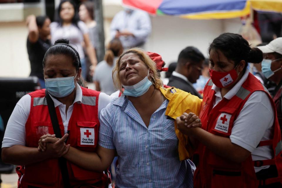 The relative of a victim of the deadly prison riot at the Centro Femenino de Adaptacion Social (CEFAS) women’s prison is helped by Red Cross paramedics outside a morgue in Tegucigalpa, Honduras (REUTERS)