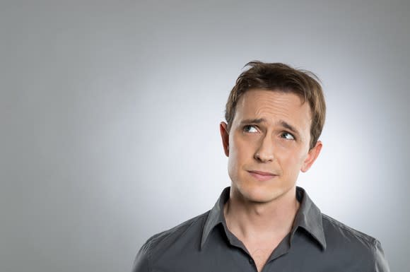 Man looking puzzled against a gray background