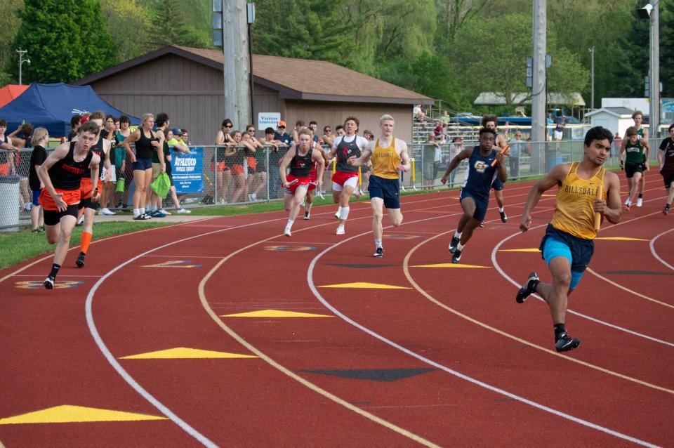 Aidan Flannery hands the baton to Jon Torres and Jonesville's Brady Wright gets the handoff from Ryan Marcavage in the 4x200-meter relay