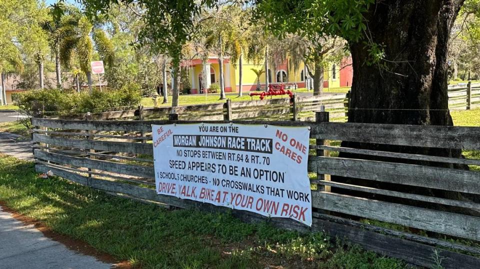 A fence sign along Morgan Johnson Road warns motorists, cyclists and walkers about worsening traffic and to use the roadway at their own risk.