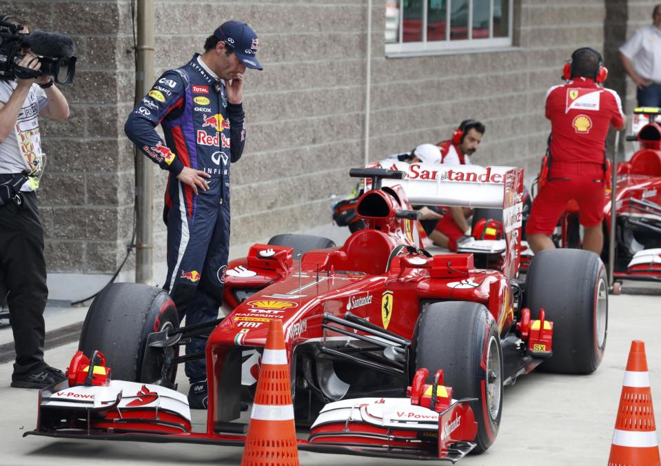 Red Bull Formula One driver Mark Webber of Australia looks at the car of Ferrari Formula One driver Fernando Alonso of Spain after the qualifying session for the Korean F1 Grand Prix at the Korea International Circuit in Yeongam, October 5, 2013. REUTERS/Lee Jae-Won (SOUTH KOREA - Tags: SPORT MOTORSPORT F1)