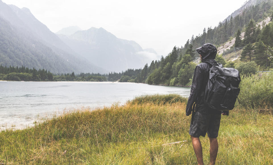 Hiker with a backpack and rain jacket on