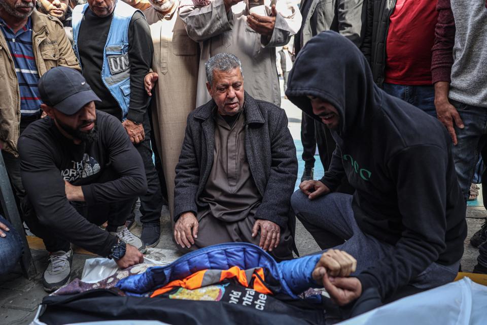 Relatives and friends mourn by the body of Saif Abu Taha, a staff member of the US-based aid group World Central Kitchen who was killed as Israeli strikes hit a convoy of the NGO delivering food aid in Gaza a day earlier, during his funeral in Rafah in the southern Gaza Strip on April 2, 2024.