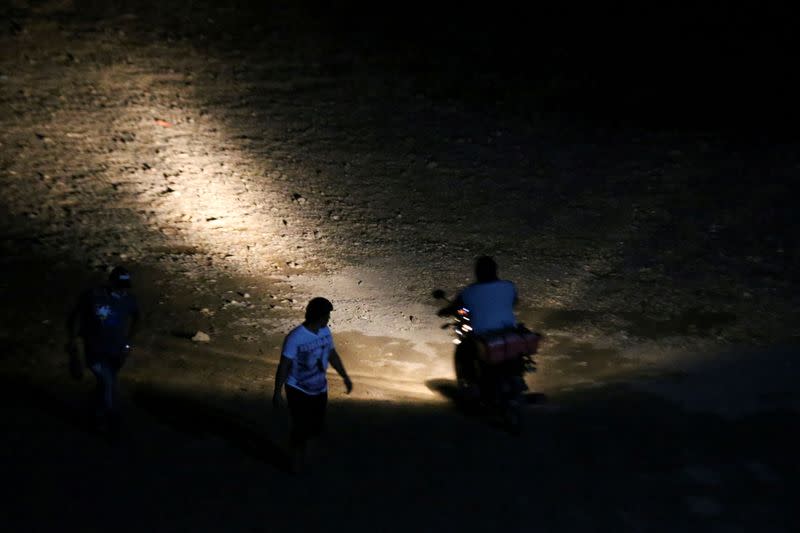 IMAGEN DE ARCHIVO. Un traficante de personas, o coyote, conduce una motocicleta en la playa después de que familias migrantes hondureñas que intentaban llegar a Estados Unidos cruzaron en un bote el río Usumacinta, en el cruce fronterizo Frontera Corozal, en México