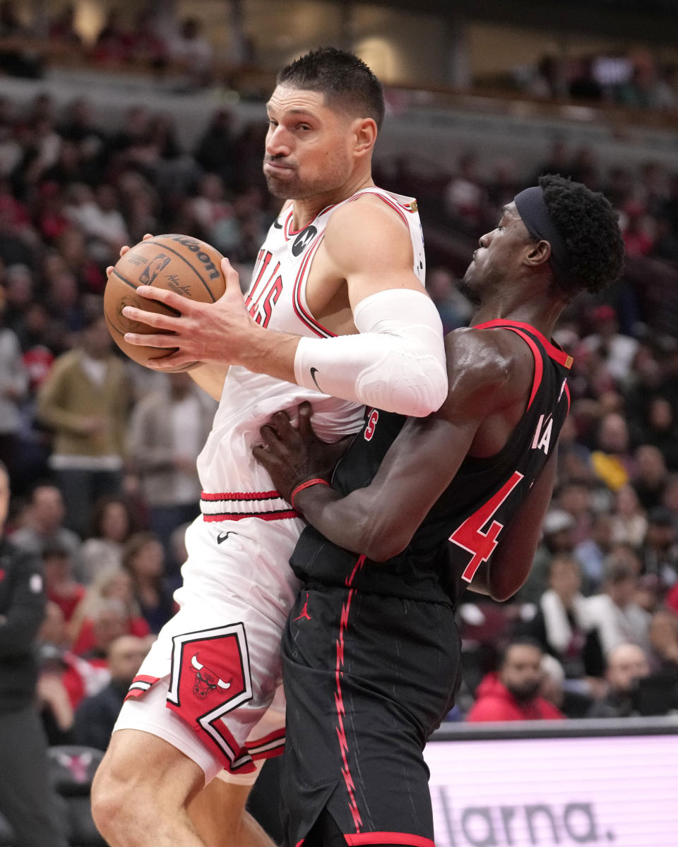 Chicago Bulls' Nikola Vucevic, left, backs into Toronto Raptors' Pascal Siakam, right, during the first half of an NBA basketball game Friday, Oct. 27, 2023, in Chicago. (AP Photo/Charles Rex Arbogast)