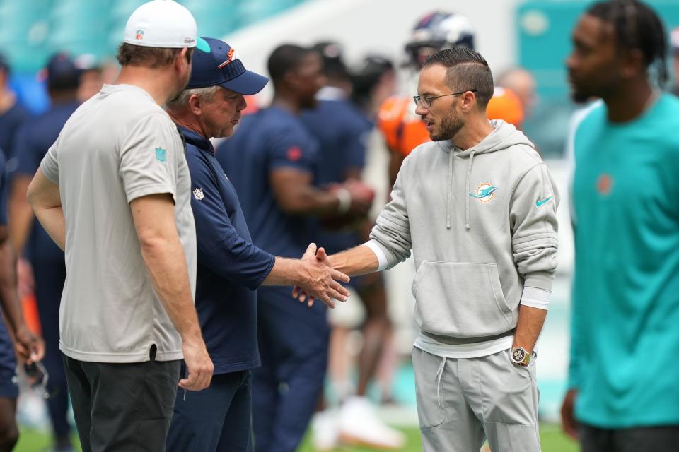 Denver Broncos head coach Sean Peyton, left, and Miami Dolphins head coach Mike McDaniel meet before an NFL game at Hard Rock Stadium in Miami Gardens, Sept. 24, 2023. 