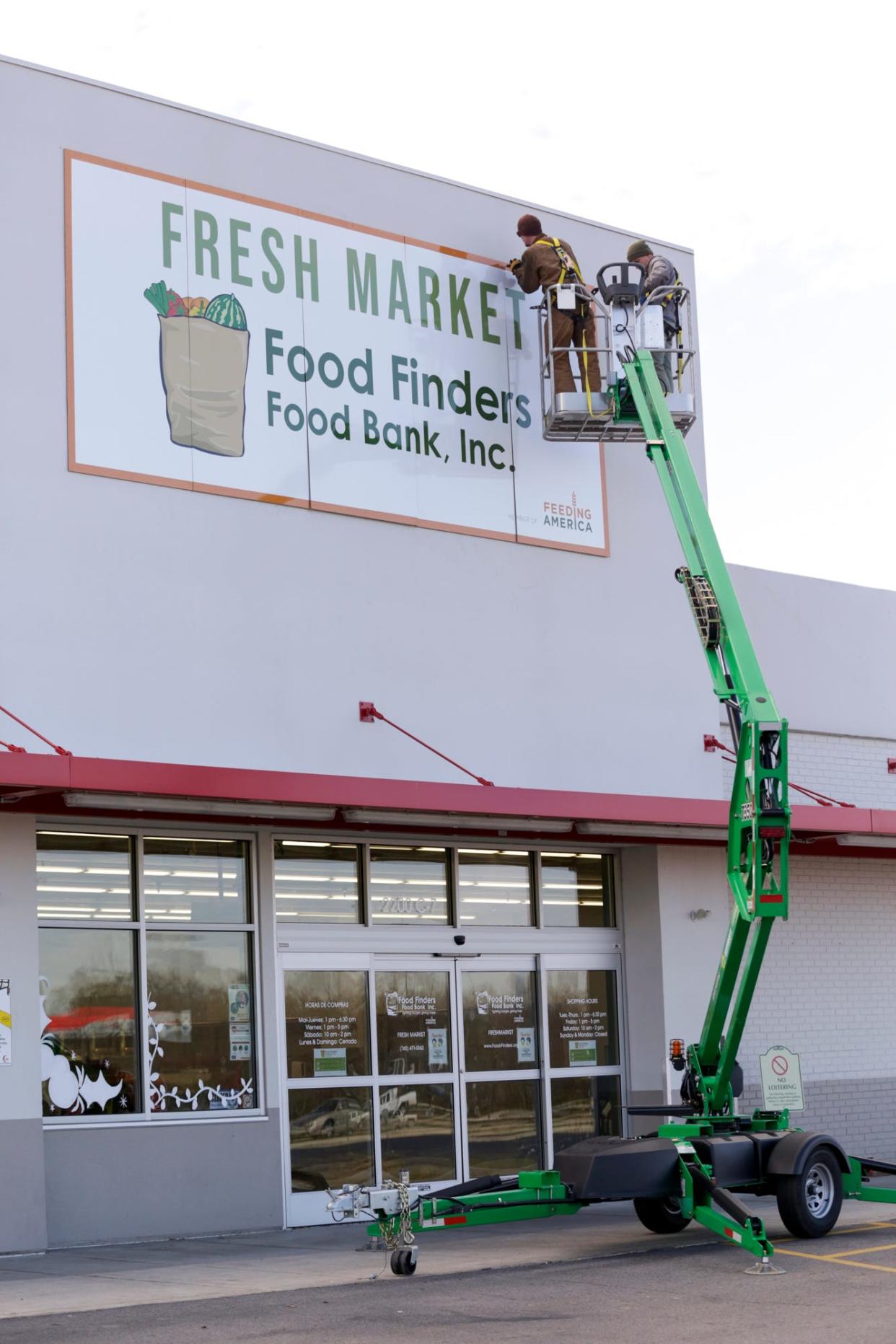 Workers install a sign for the Food Finders Food Bank Fresh Market, 2200 Elmwood Ave., Thursday, Dec. 3, 2020 in Lafayette.