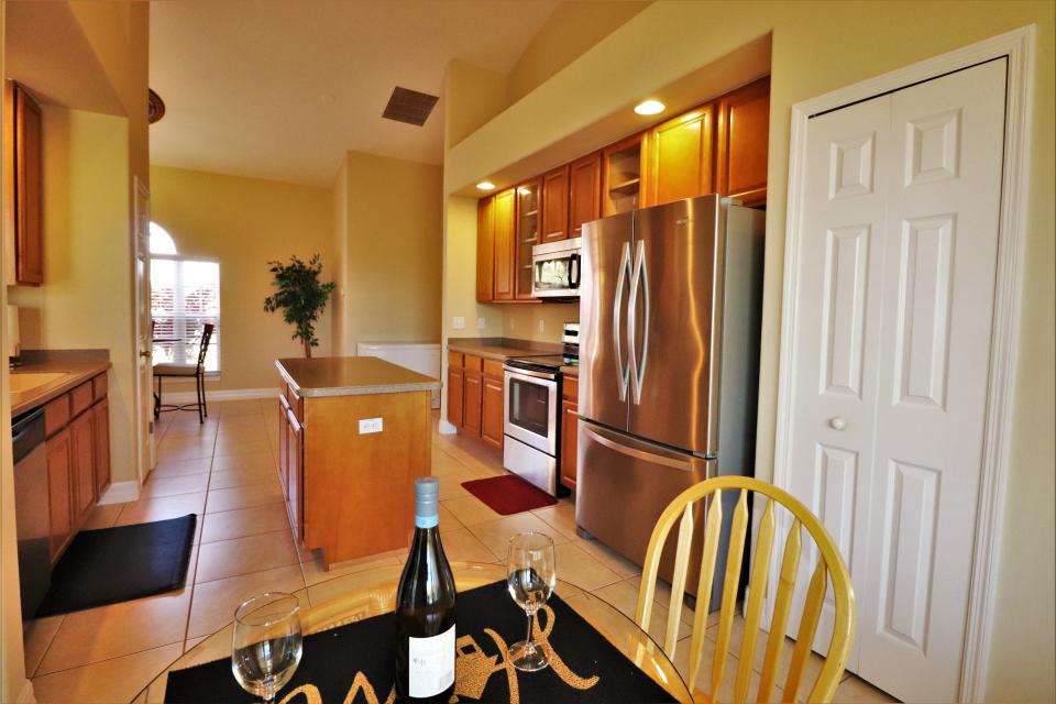 The eat-in kitchen features a stainless-steel appliance package, center island and tile flooring.