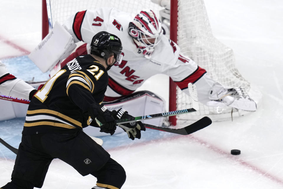 Boston Bruins left wing James van Riemsdyk (21) reaches for the puck as Carolina Hurricanes goaltender Spencer Martin (41) pounces on it during the first period of an NHL hockey game Wednesday, Jan. 24, 2024, in Boston. (AP Photo/Charles Krupa)