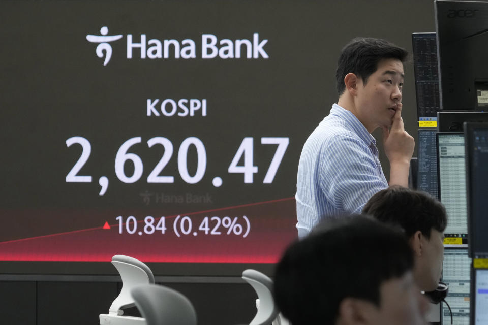 A currency trader watches monitors near the screen showing the Korea Composite Stock Price Index (KOSPI) at the foreign exchange dealing room of the KEB Hana Bank headquarters in Seoul, South Korea, Wednesday, April 17, 2024. (AP Photo/Ahn Young-joon)