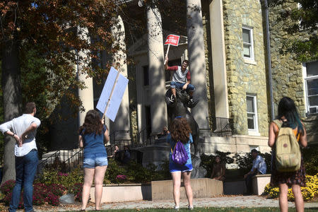 Gerard Consorti, 21, a West Chester University junior, holds an "On Strike" sign atop a sculpture of the ram mascot during a demonstration with university employees from the union representing 5,500 Pennsylvania university and college employees after failing to reach a contract deal with the state education system in West Chester, Pennsylvania, U.S., October 19, 2016. REUTERS/Mark Makela