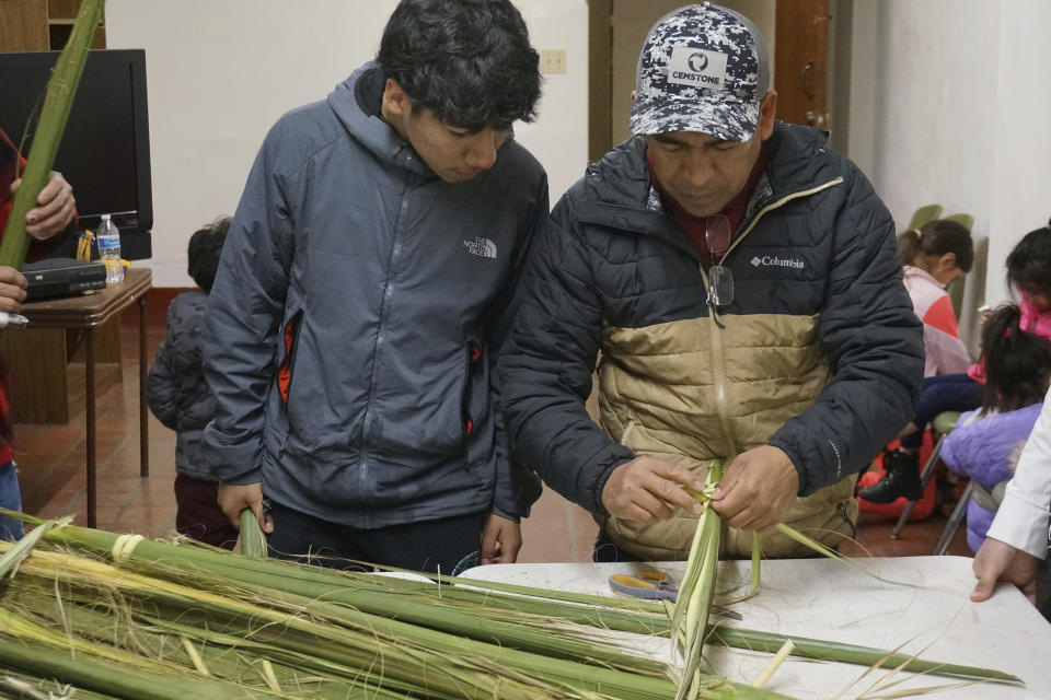 Reynaldo Hidalgo, right, teaches a volunteer how to weave palm fronds at the Church of the Incarnation in Minneapolis on Wednesday, March 29, 2023. Hidalgo and his wife started holding weaving workshops at the Catholic parish half a dozen years ago, joining faith and traditional crafts from their native Mexico to celebrate Palm Sunday, the start of Christianity’s holiest week. (AP Photo/Giovanna Dell’Orto)