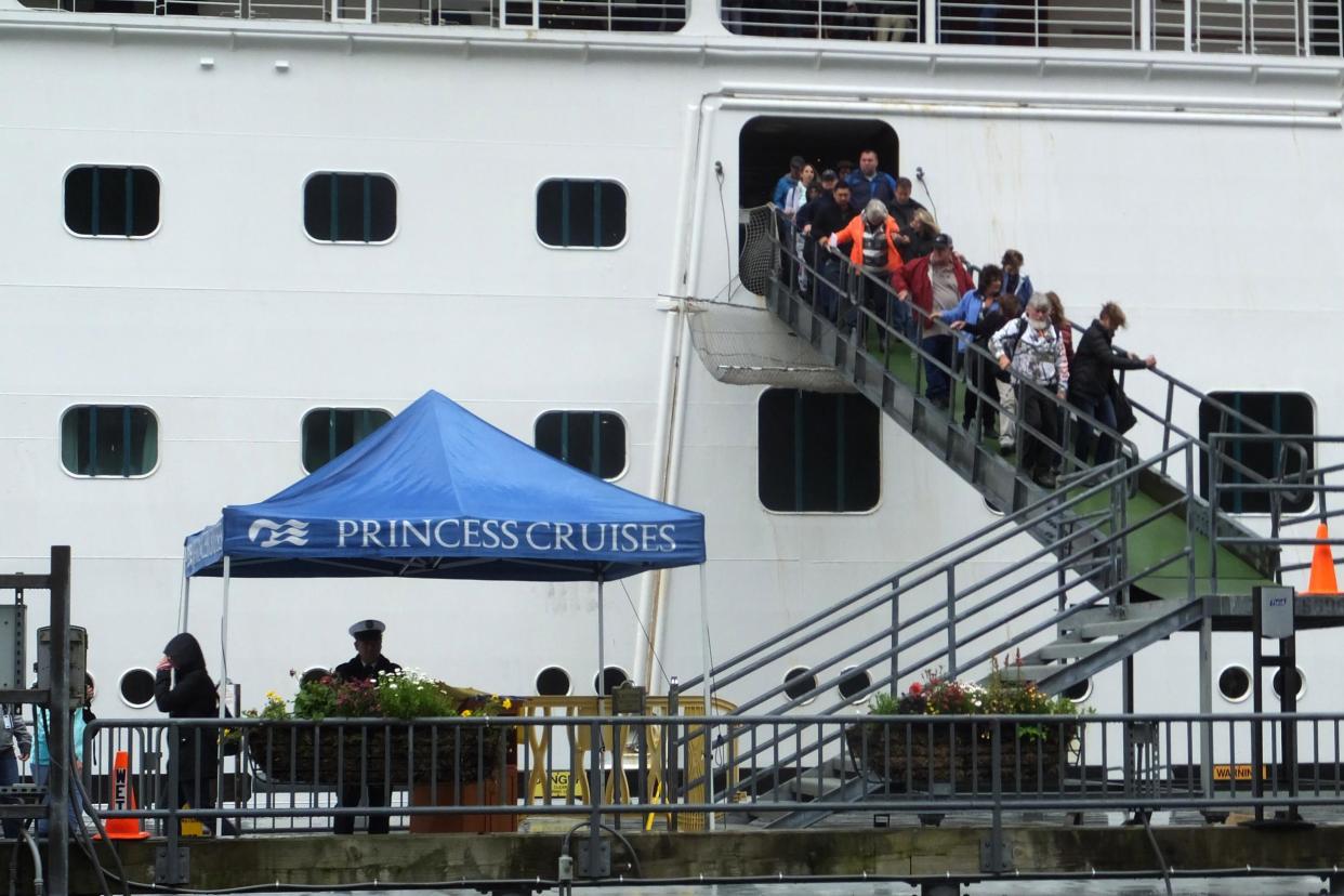 Passengers of the Emerald Princess cruise ship disembark on Wednesday after a woman was found dead: AP