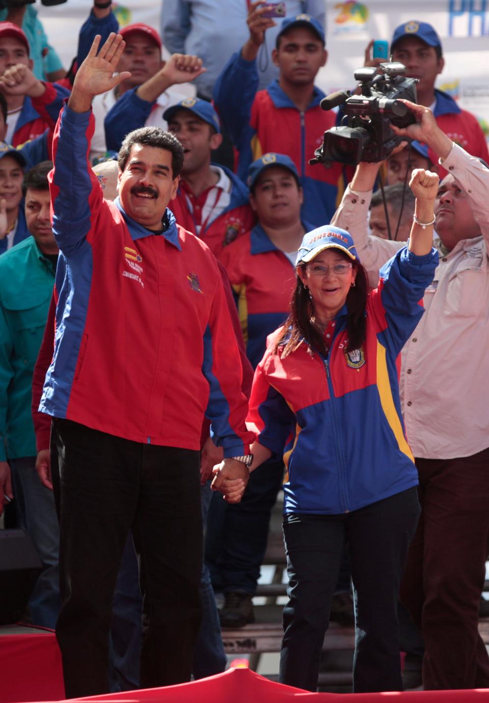 Venezuela's President Nicolas Maduro and his wife Cilia Flores greet supporters upon their arrival for a meeting with students in Caracas, Venezuela, Saturday, March 22, 2014. Two more people were reported dead in Venezuela as a result of anti-government protests even as supporters and opponents of Maduro took to the streets on Saturday in new shows of force. (AP Photo/Esteban Felix)