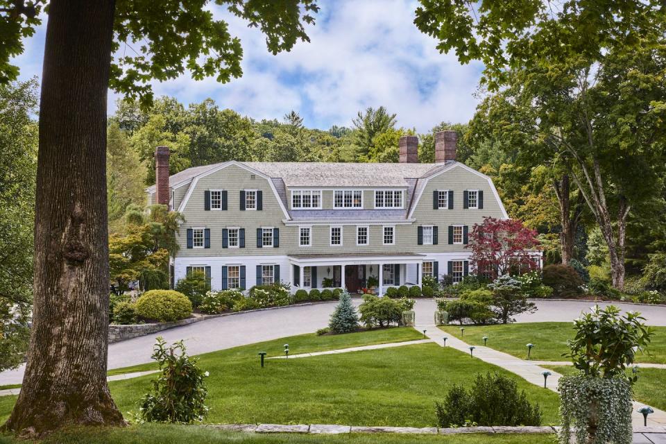 a large white house with trees and grass in front of it